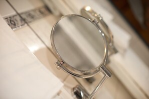 A bathroom mirror with a metallic frame, a towel rack, and a visible toilet paper roll. - Akzent Hotel Hubertus (Melle)