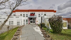 A building with a red roof and white walls, labeled "Airport Hotel."