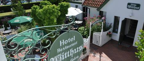 Indicador d'hotel amb la inscripció "Hotel Restaurant Sittus" i "Teestuben • Galerie", que anuncia una zona de restauració i una galeria.