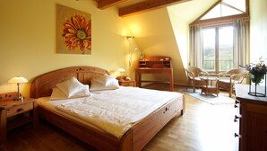 Un dormitorio con una cama de madera, un escritorio y una silla cerca de la ventana.
