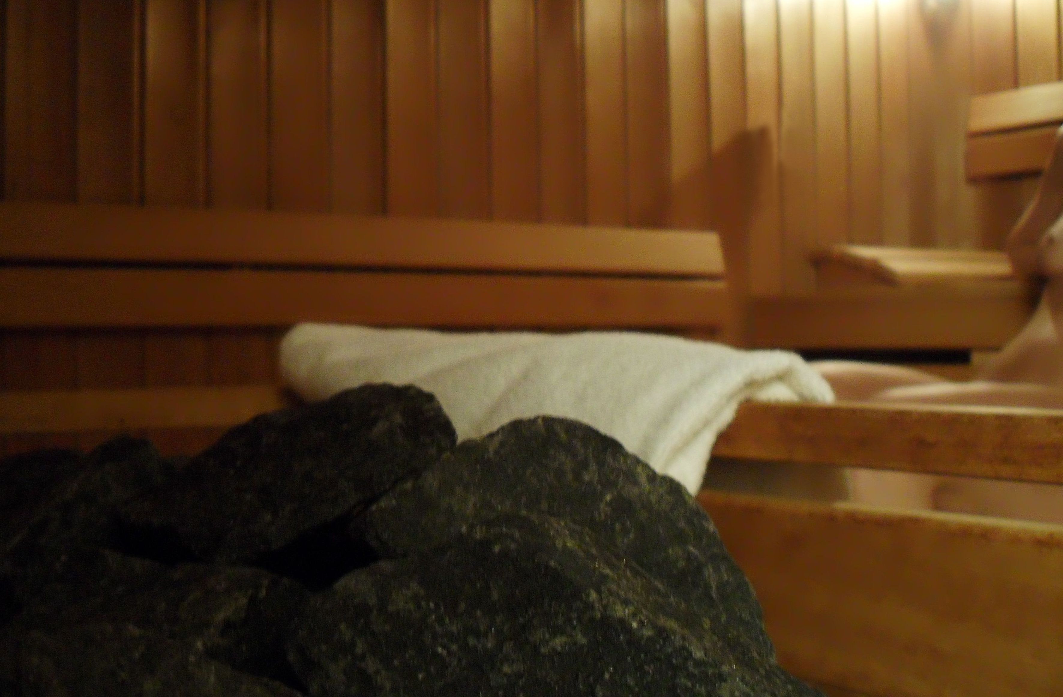 A wooden bench with a white towel draped over it, suggesting a spa or relaxation area.