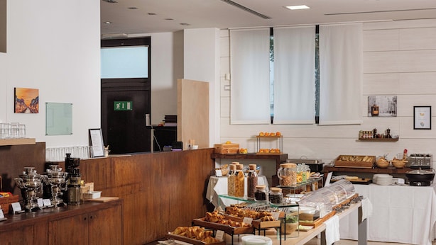 A buffet area with various food items and a wooden counter. - Phi Hotel Milano (Baranzate)