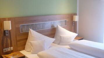 Habitación de hotel con una cama grande, dos mesitas de noche y una lámpara de pared.