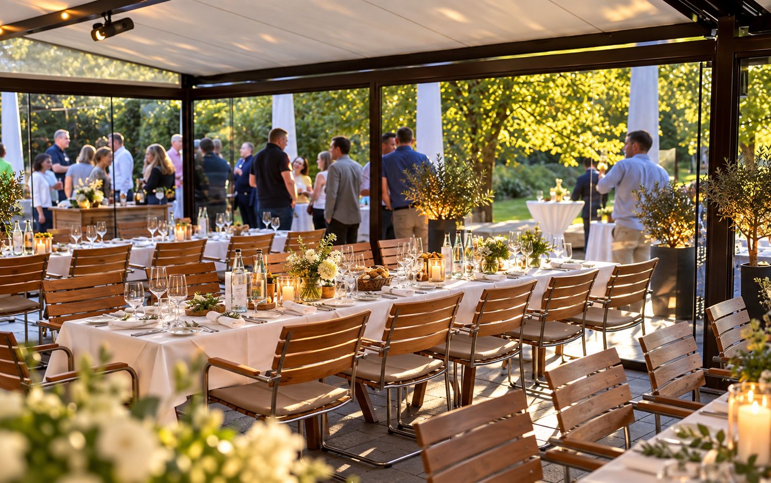 An outdoor dining area with tables set for guests, surrounded by greenery and trees.