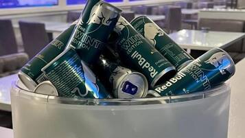 Een metalen bak met reliëfdecoraties, gevuld met blikjes drank.