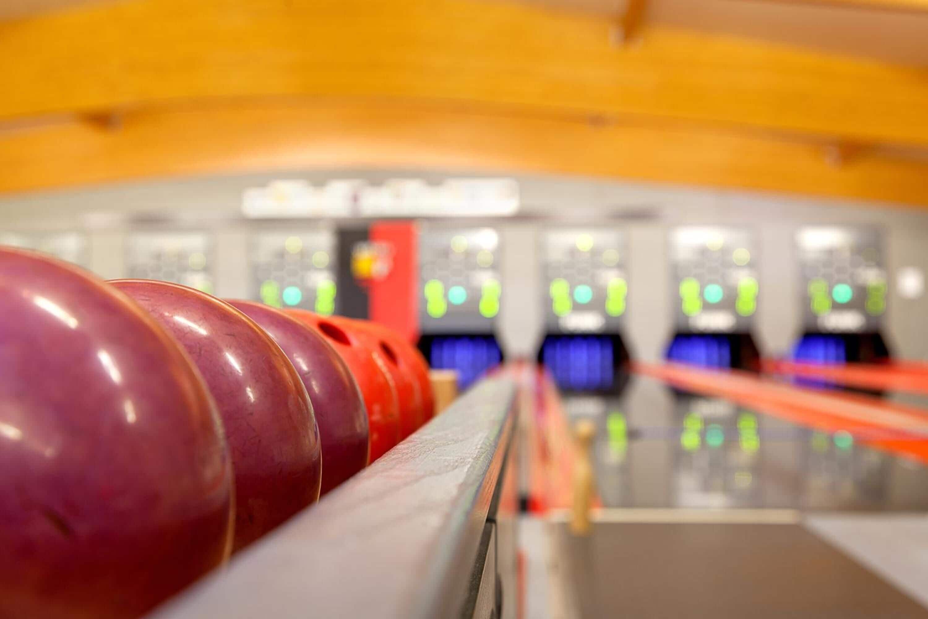 En bowlinghall med flera banor och uppradade bowlingklot.