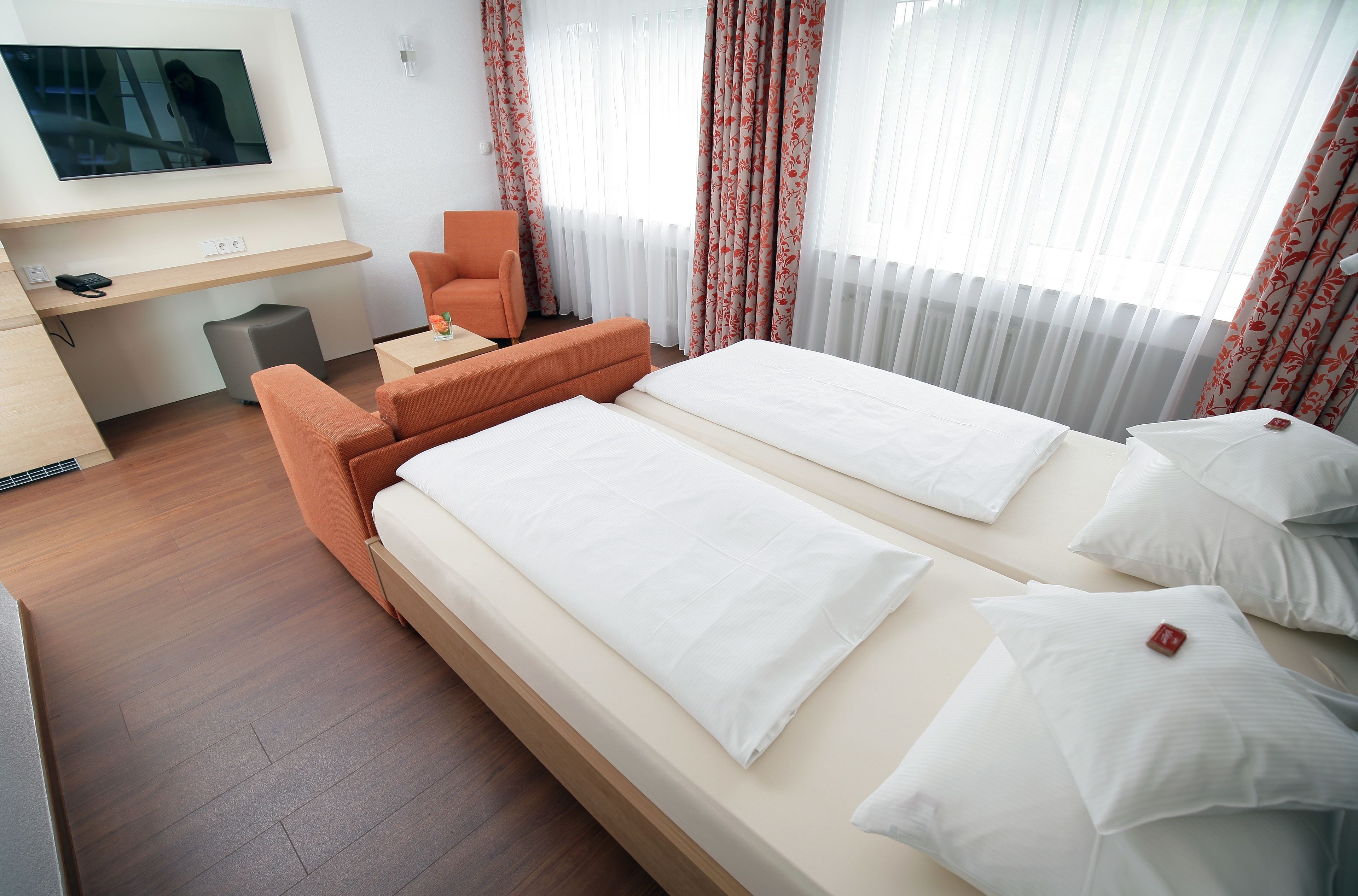 Een hotelkamer met een bed, een bureau, een stoel en een televisie.