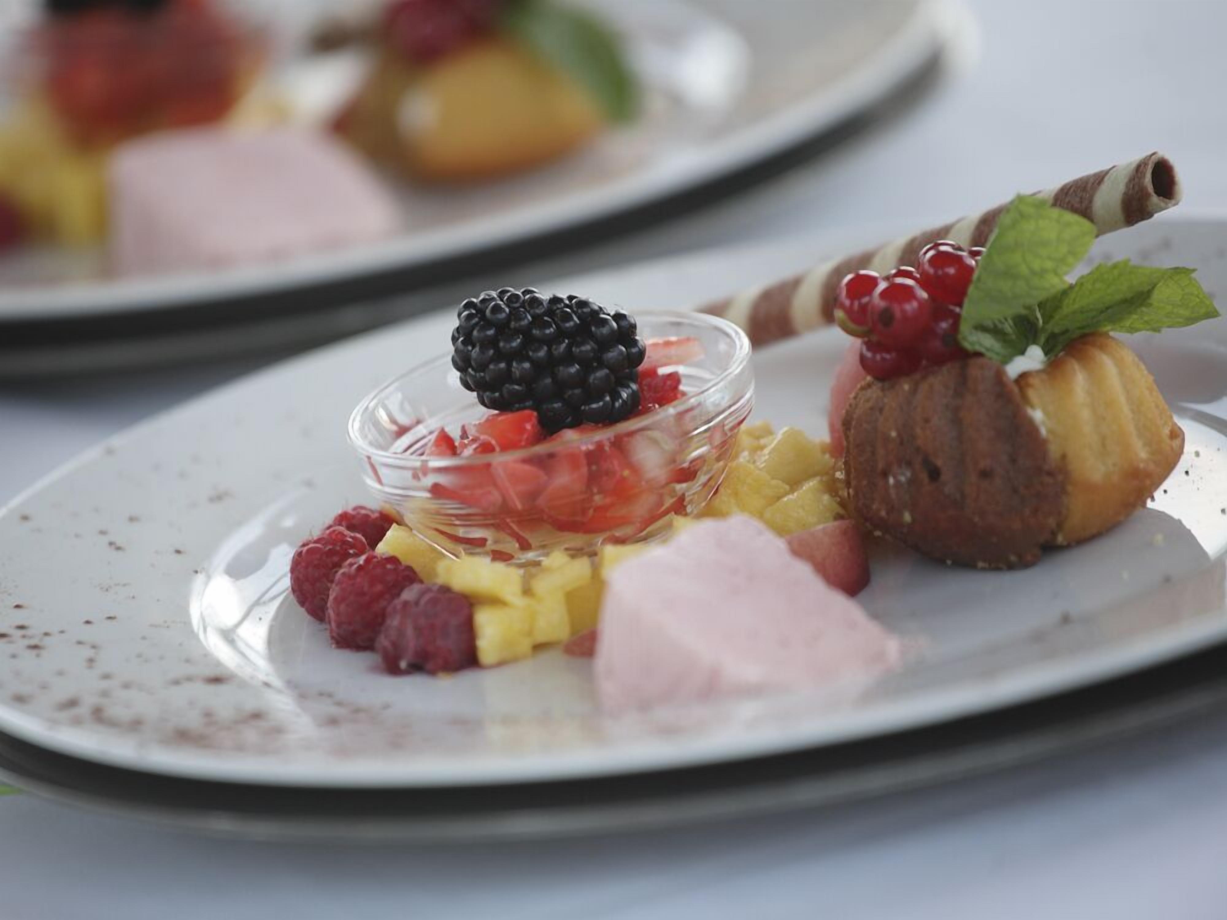 Een nagerechtenbord met diverse soorten fruit en gebak.