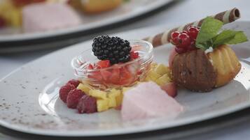 Een nagerechtenbord met diverse soorten fruit en gebak.