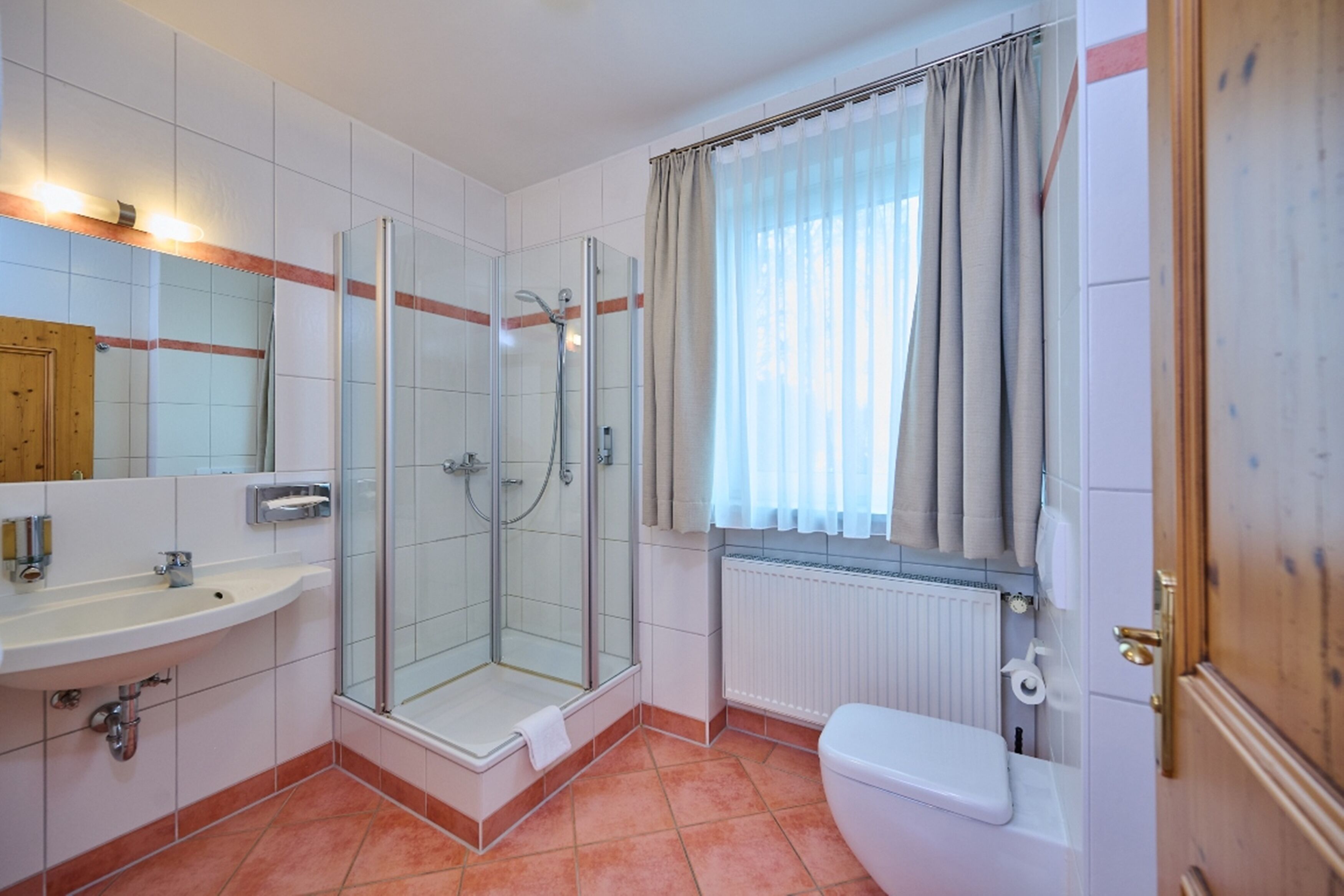 Une salle de bain avec une douche à parois de verre, un lavabo et des toilettes.