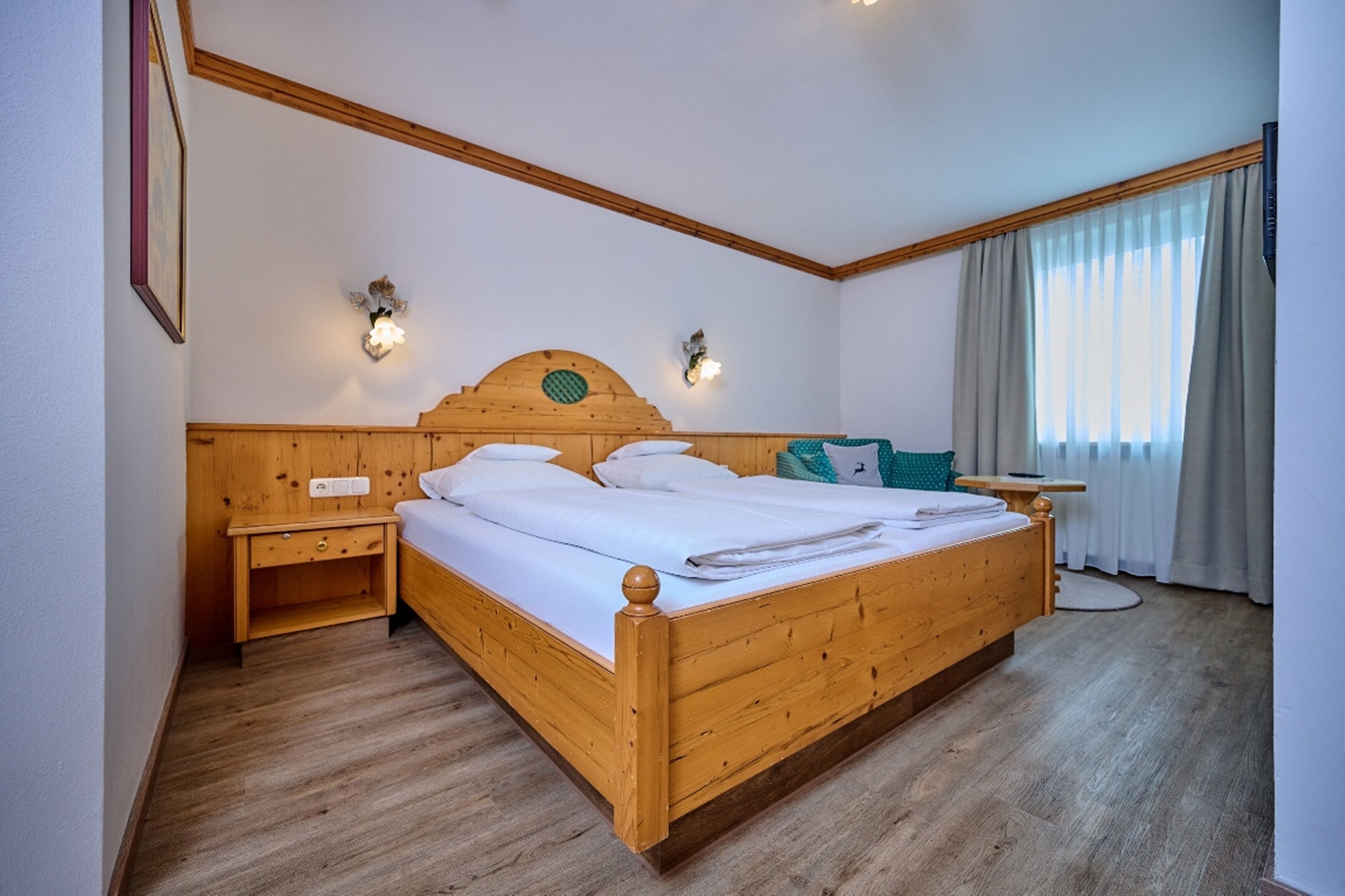 Ein hölzernes Bett mit Kopfteil, Nachttisch und Beistelltisch.