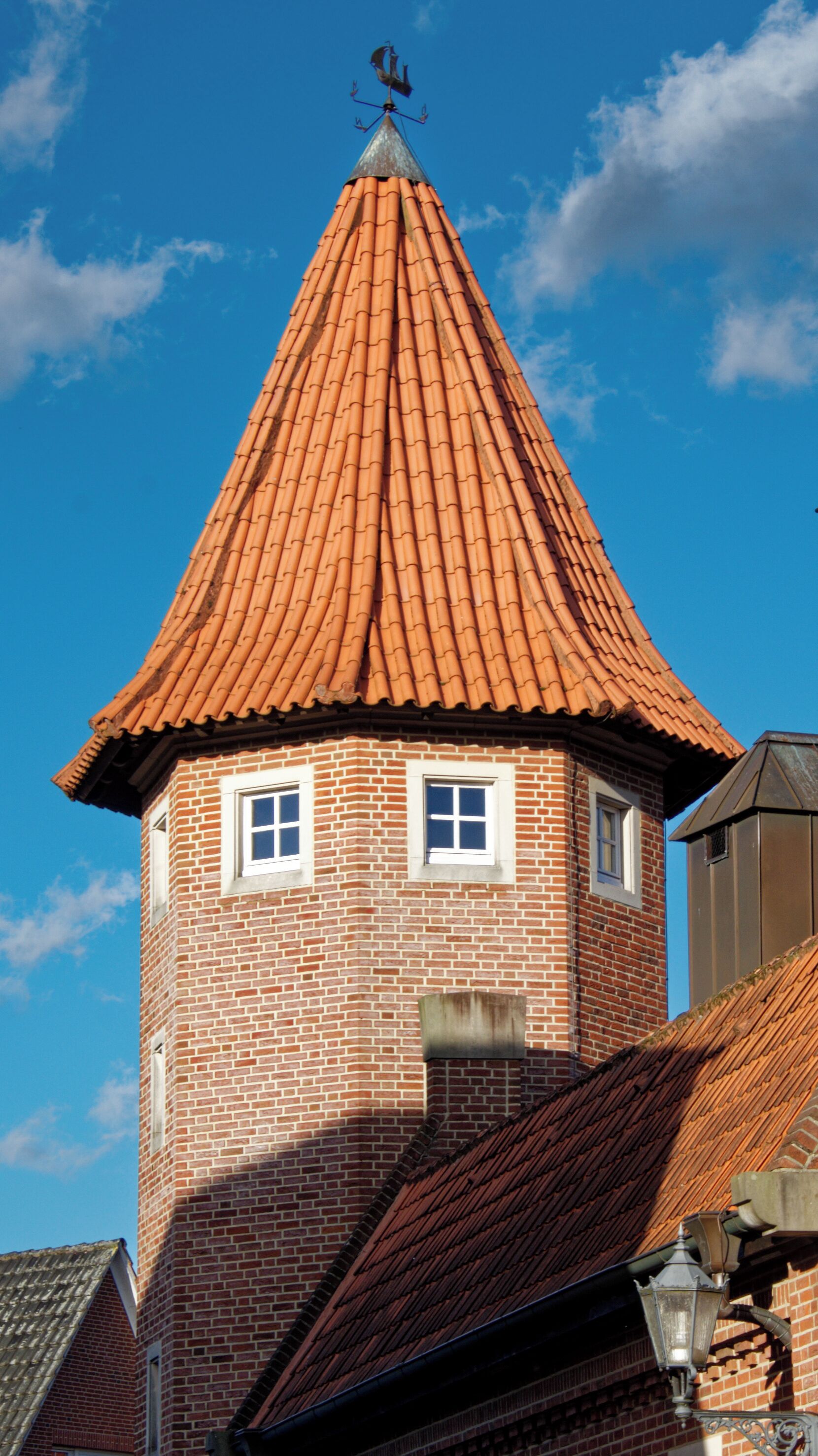 Una torre de ladrillo con techo cónico y dos ventanas.