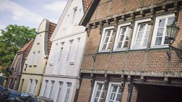 A row of traditional European buildings with uniform window designs and brick facades.