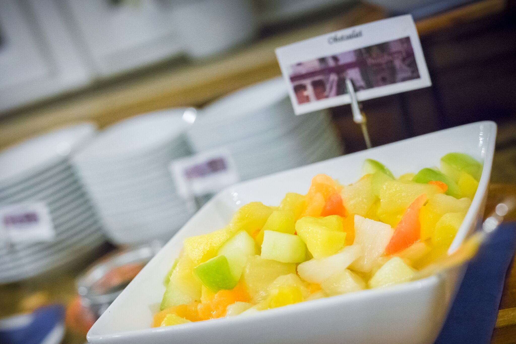 Un tazón de ensalada de frutas con un letrero que dice 'Cítricos'.