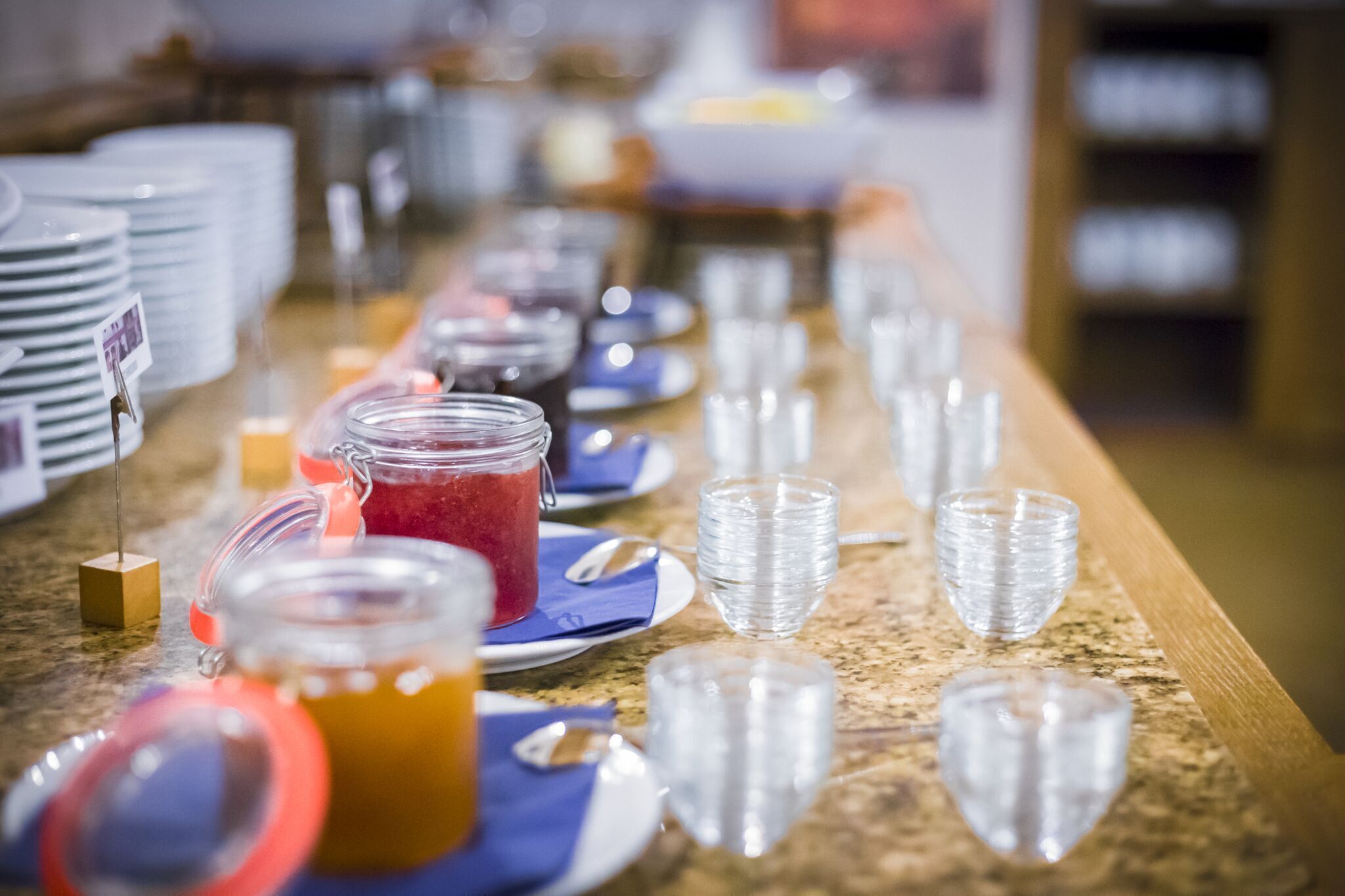 A buffet setup with various food items and clear glassware.