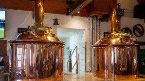 Two copper brewing kettles on a wooden counter in a brewery. - Brauhaus Wiesenmühle (Fulda)