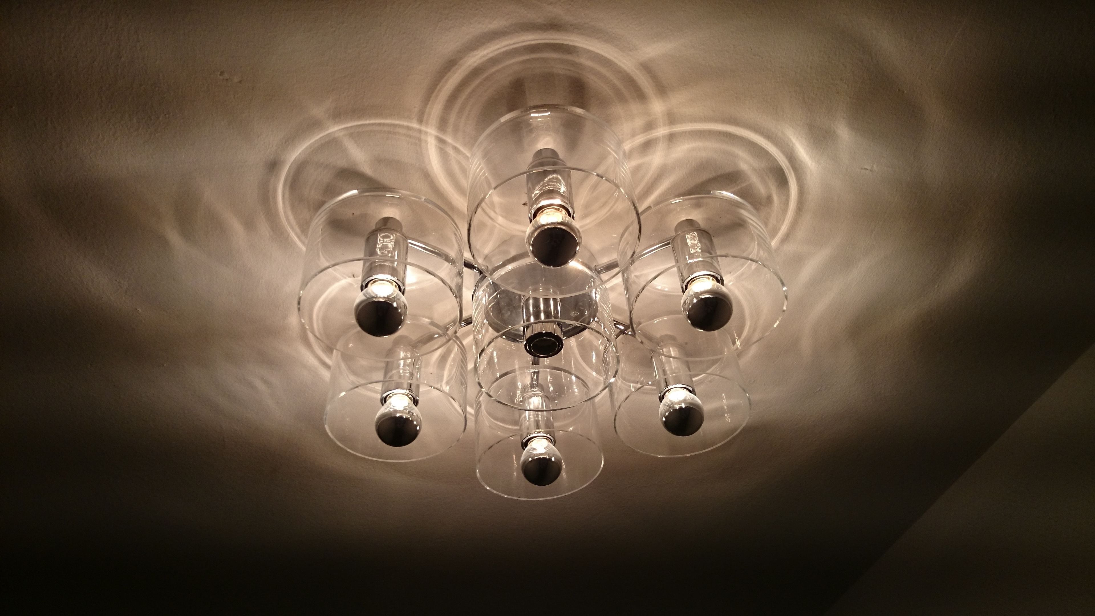 Techo con una lámpara central rodeada de varias luces más pequeñas.
