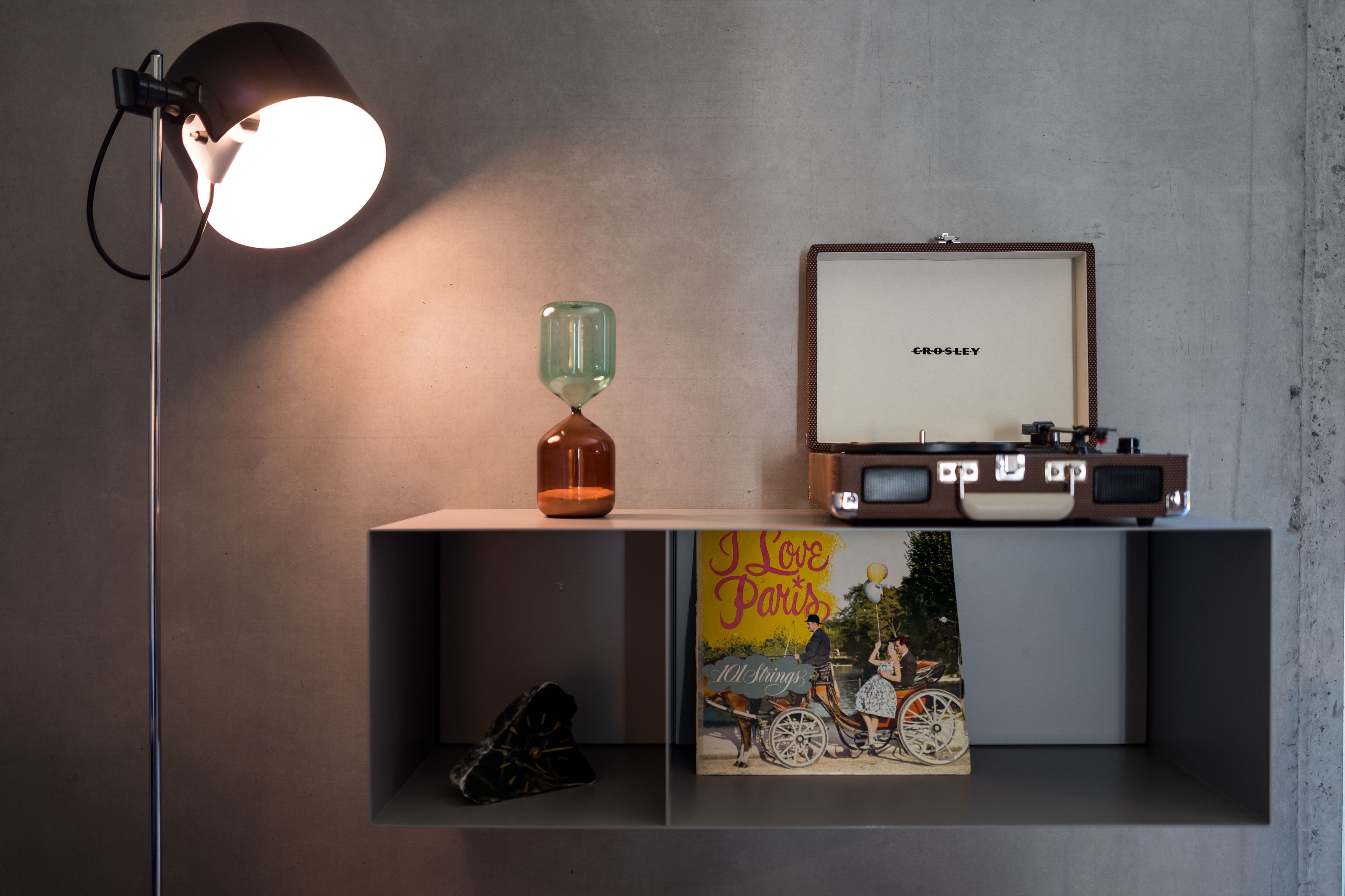 Une étagère avec un tableau encadré, un livre intitulé « J’aime Paris » et une radio ancienne.