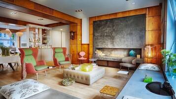 Una sala de estar moderna con chimenea, paneles de madera y una zona de bar.