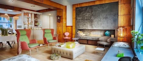 A modern living room with a fireplace, wooden paneling, and a bar area.