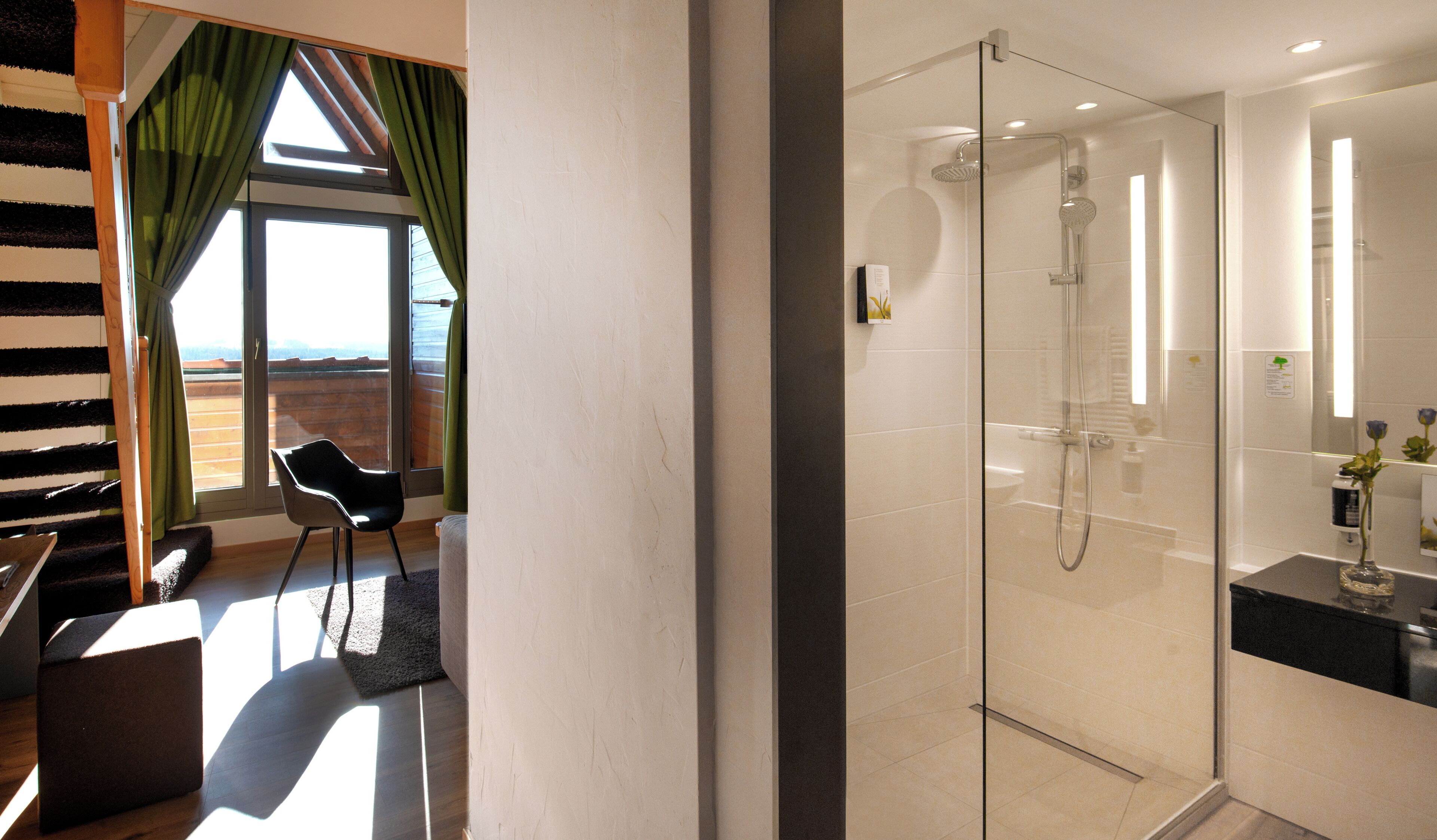 A modern bathroom with a glass-enclosed shower, a sink with a mirror, and a small vase with flowers on the counter.
