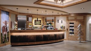 Un espace d’accueil comprenant un comptoir de réception en bois, un certificat encadré et un réfrigérateur fixé au mur.
