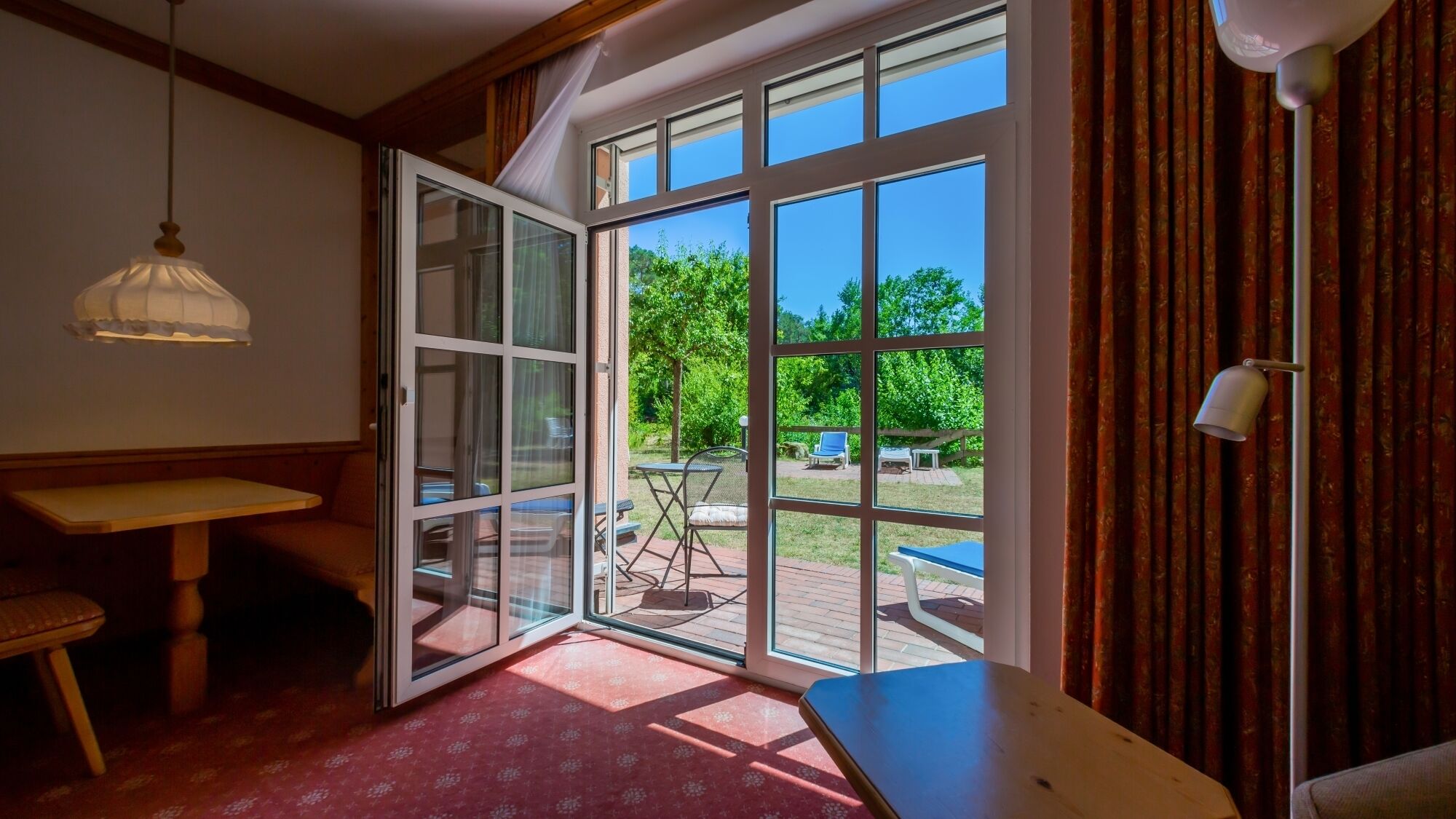 A room with a large sliding glass door leading to an outdoor patio area.