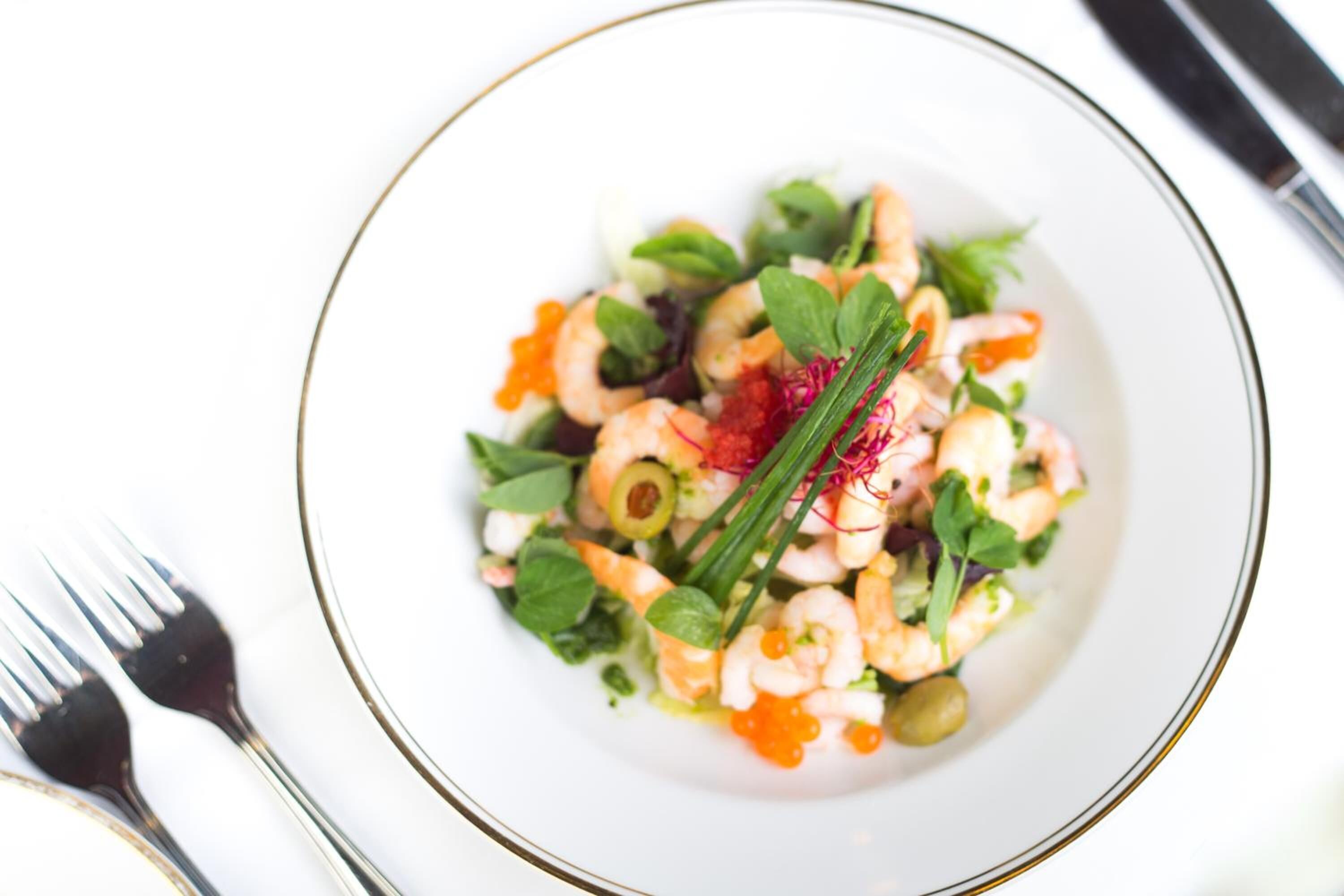 Ensalada de camarones con vegetales y una guarnición.