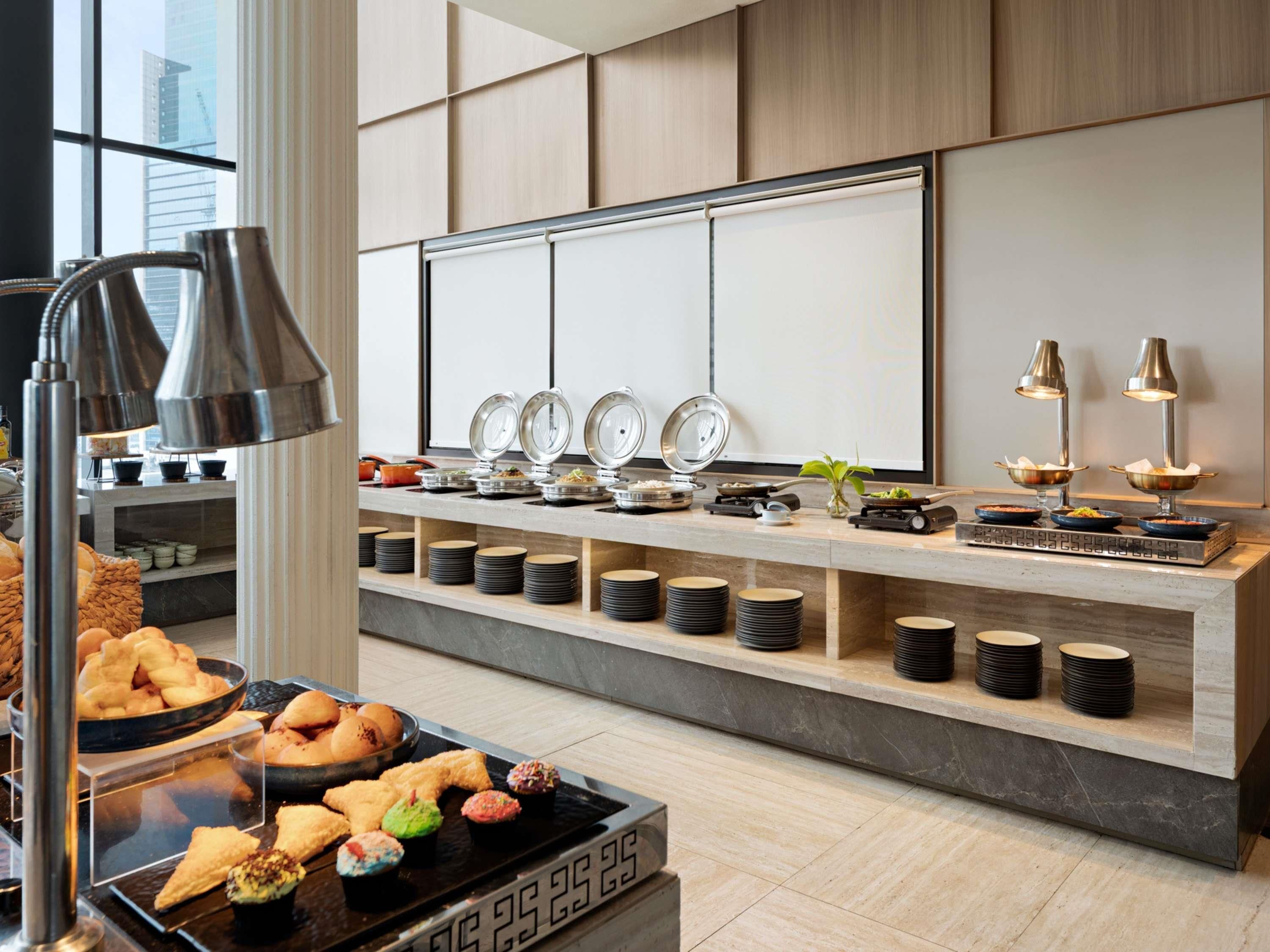 A buffet setup with various food items and a modern interior design.