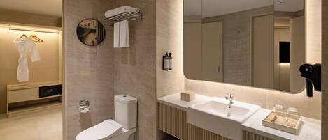 A modern bathroom with a toilet, sink, and mirror.