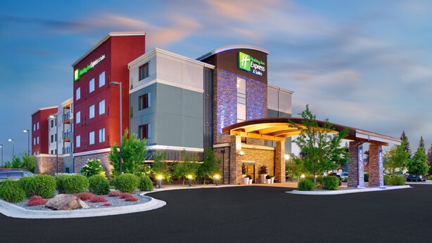 Un hôtel Holiday Inn Express & Suites au design moderne, doté d’une entrée imposante et d’un environnement paysager soigné.