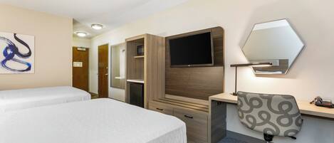 Een hotelkamer met twee bedden, een bureau, een stoel, een televisie en een spiegel.