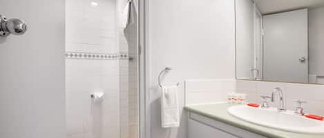 A modern bathroom with a shower, toilet, and sink.