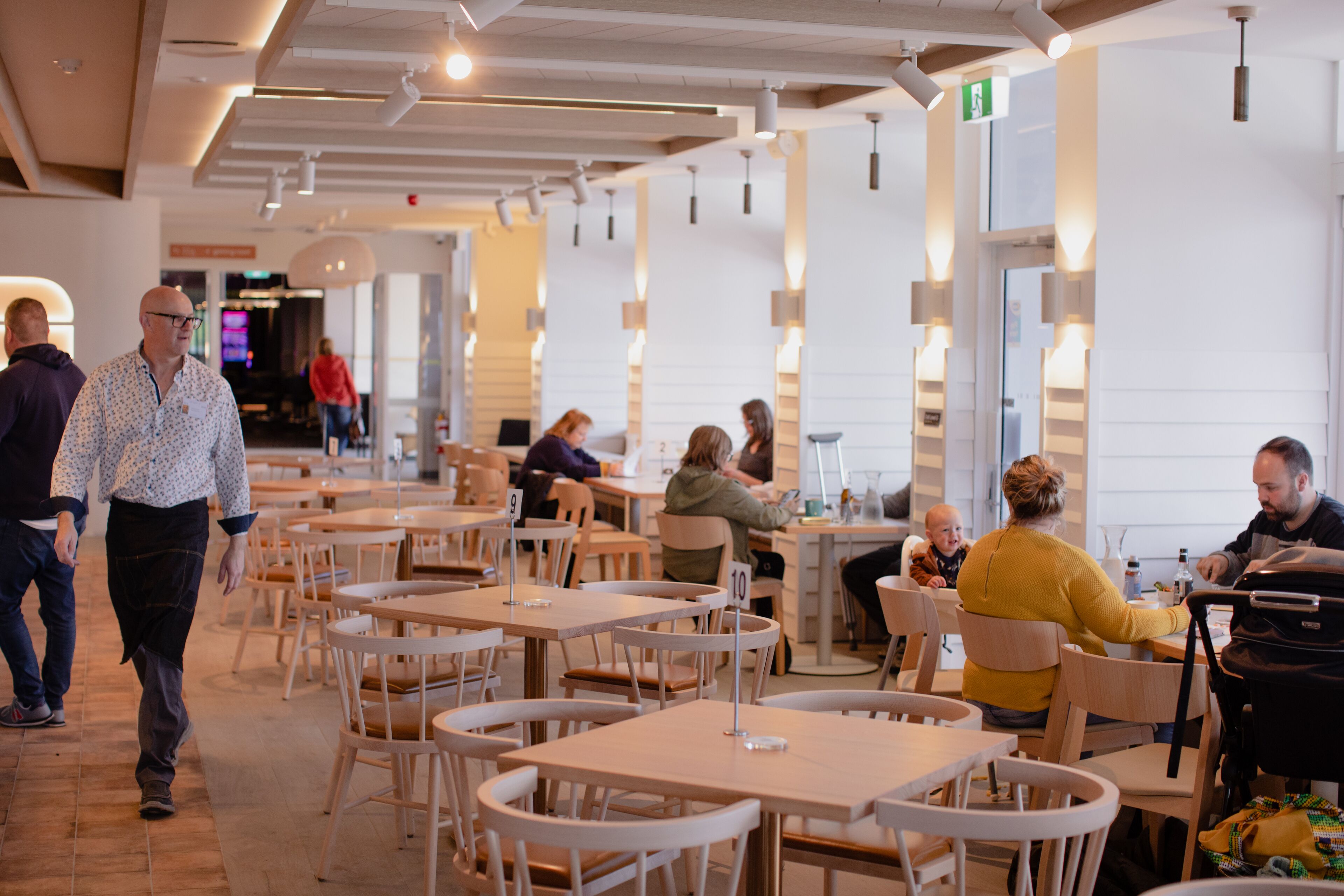 A spacious indoor dining area with multiple tables and chairs, a clean and modern design, and a bright, well-lit environment.