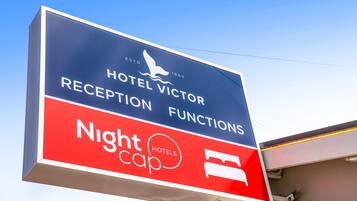 Ein Hotelschild mit dem Schriftzug "Hotel Victor" und den Hinweisen "Rezeption Veranstaltungen" und "Nightcap Hotels".