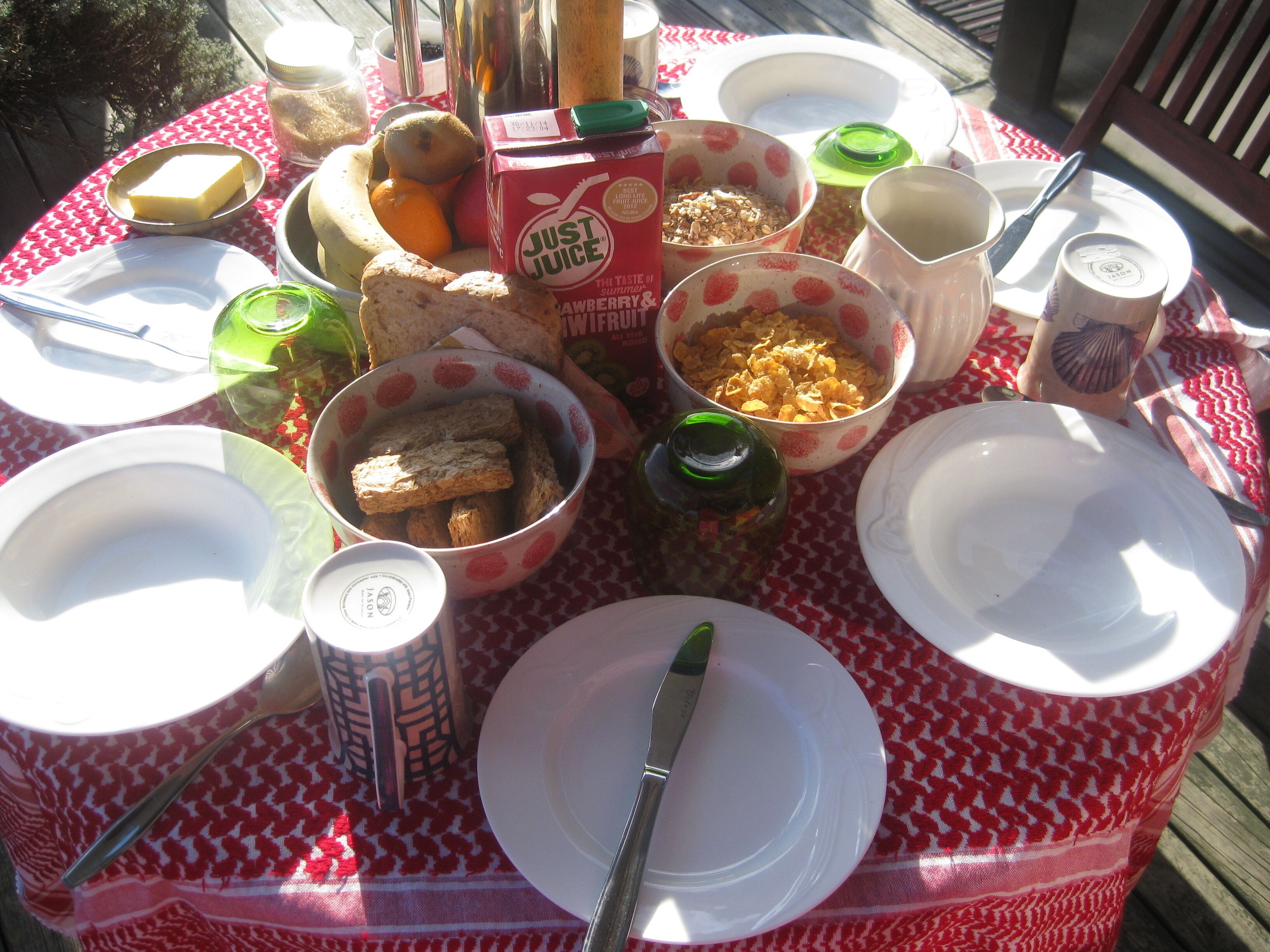 Una mesa de picnic con diversa comida y utensilios.