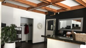 Una cocina moderna con techo de madera, un reloj grande y una planta en maceta.