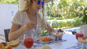 A dining table with various breakfast items including toast, eggs, and fruit. - Hotel Casa De Las Flores (San Andrés)