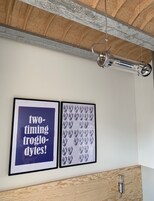 Una stanza con soffitto in legno, un'opera d'arte incorniciata con testo e una parete decorata.