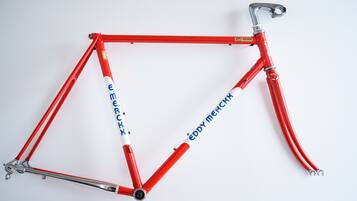 A red bicycle with the brand name 'Eddy Merckx' on the frame.