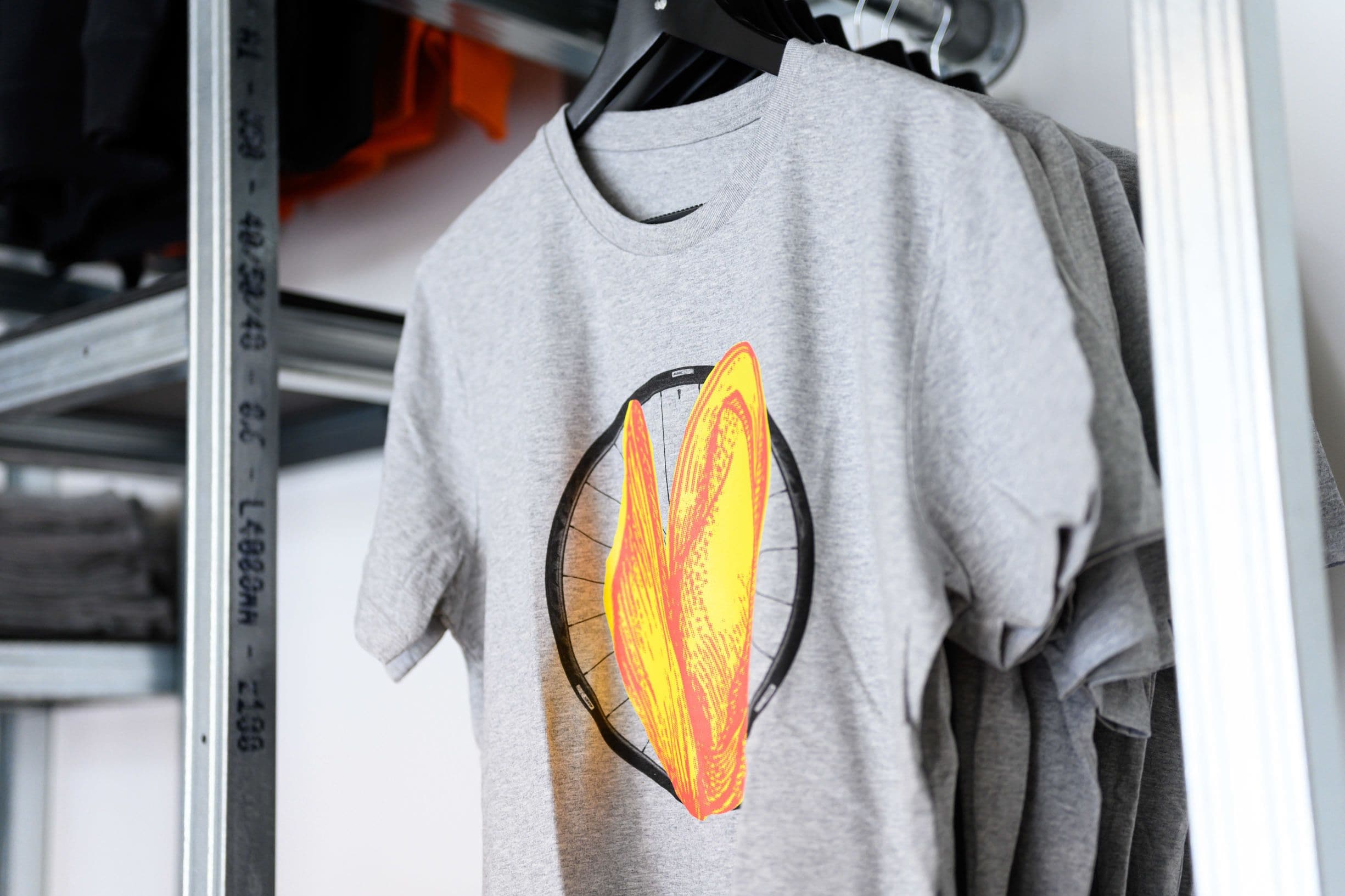 Una camiseta gris con un diseño gráfico colgada en un perchero.