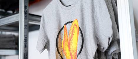 Una camiseta gris con un diseño gráfico colgada en un perchero.