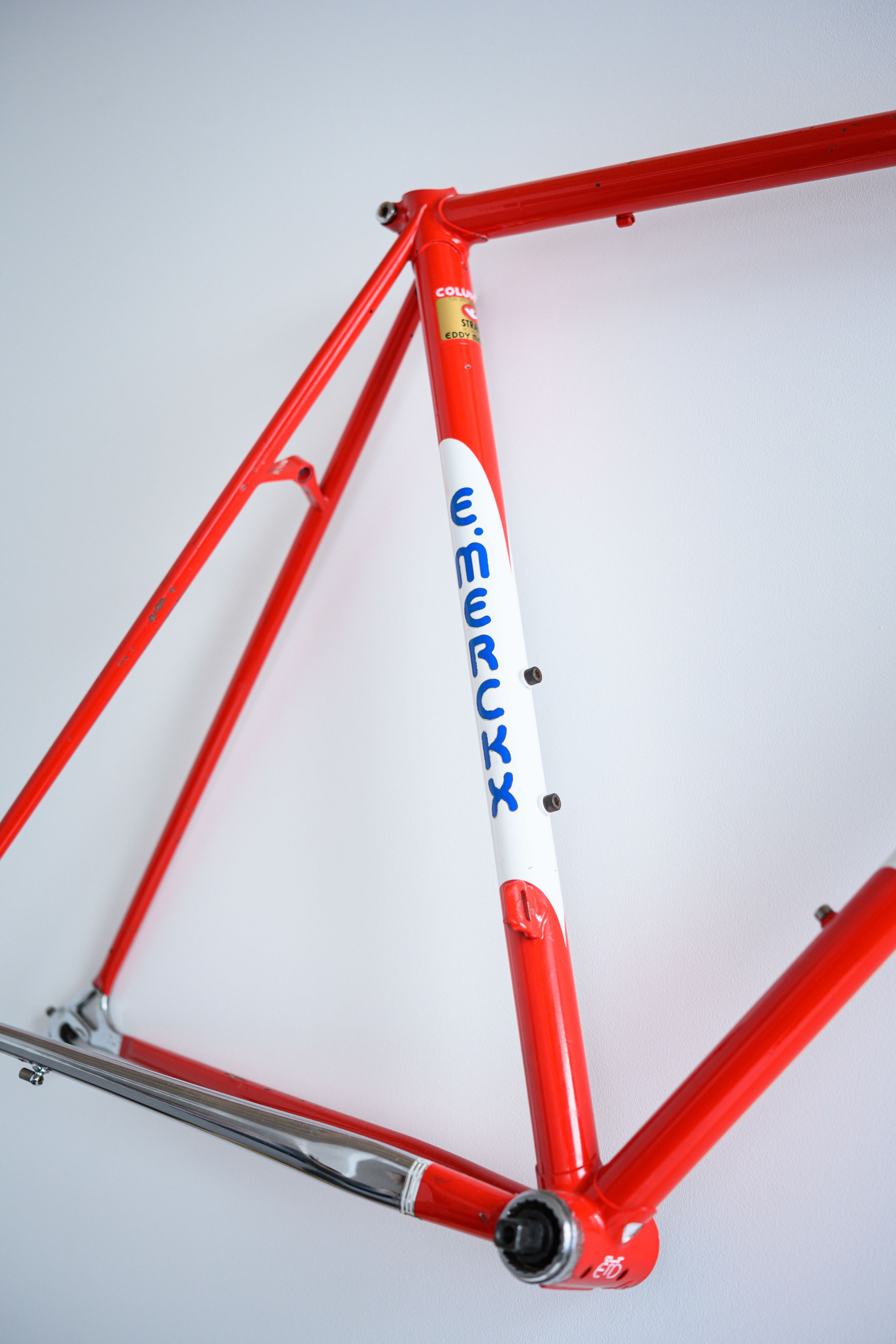 A red and white bicycle frame with the name "Emerckx" visible.