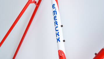 A red and white bicycle frame with the name "Emerckx" visible.