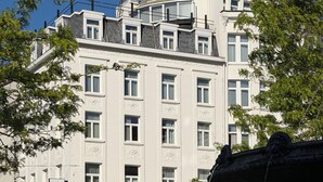 A hotel with a classic facade, multiple windows, and a sign indicating it is a hotel. - Hotel La Grande Cloche (Brussels)
