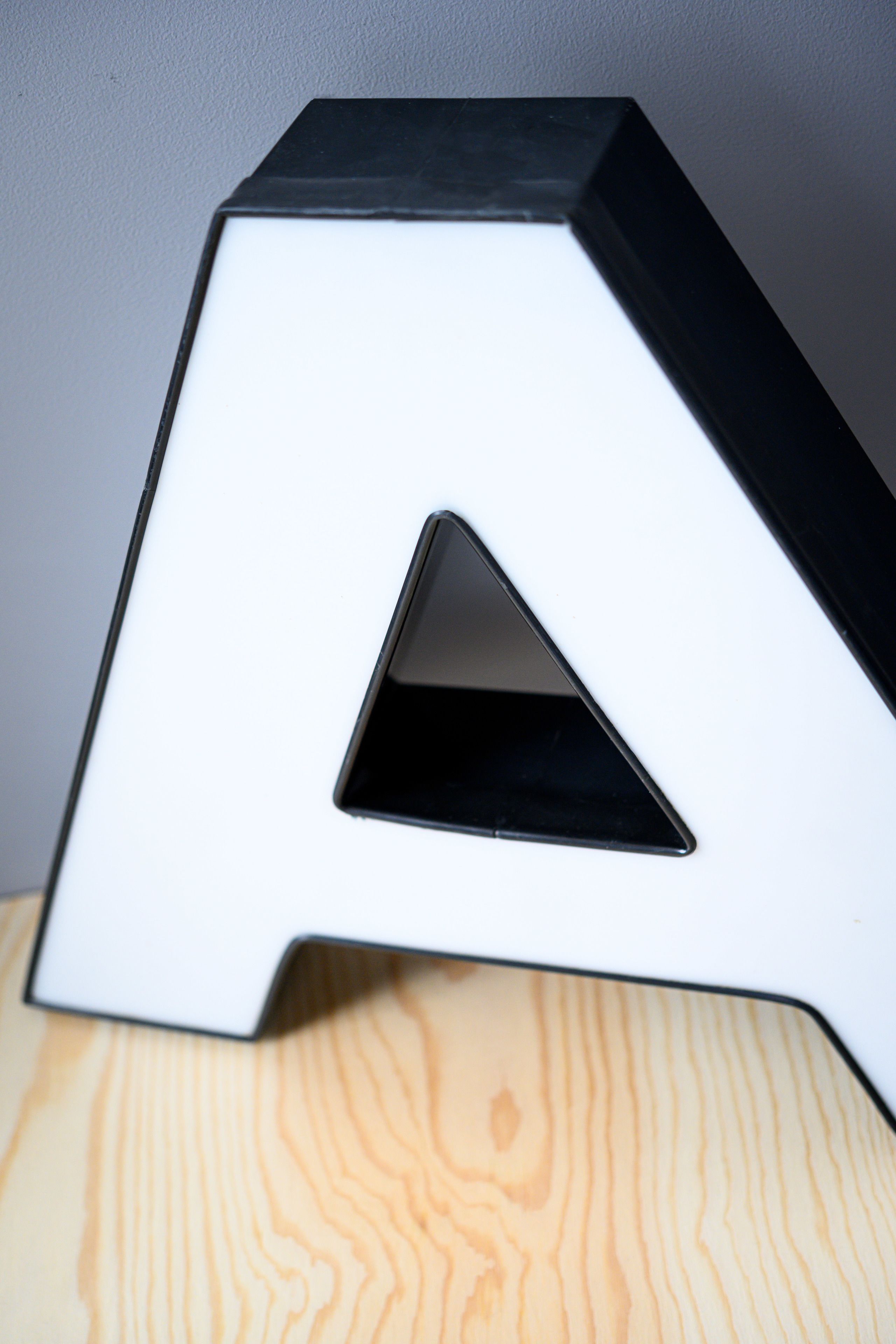 A white, angular object with a triangular cutout, placed on a wooden surface.