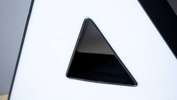 A white, angular object with a triangular cutout, placed on a wooden surface.