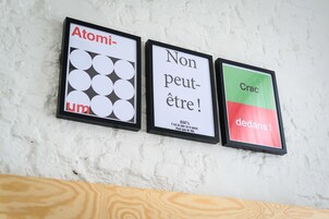 Three framed signs on a white textured wall.