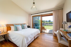 Un dormitorio con una cama grande, un escritorio y un televisor.
