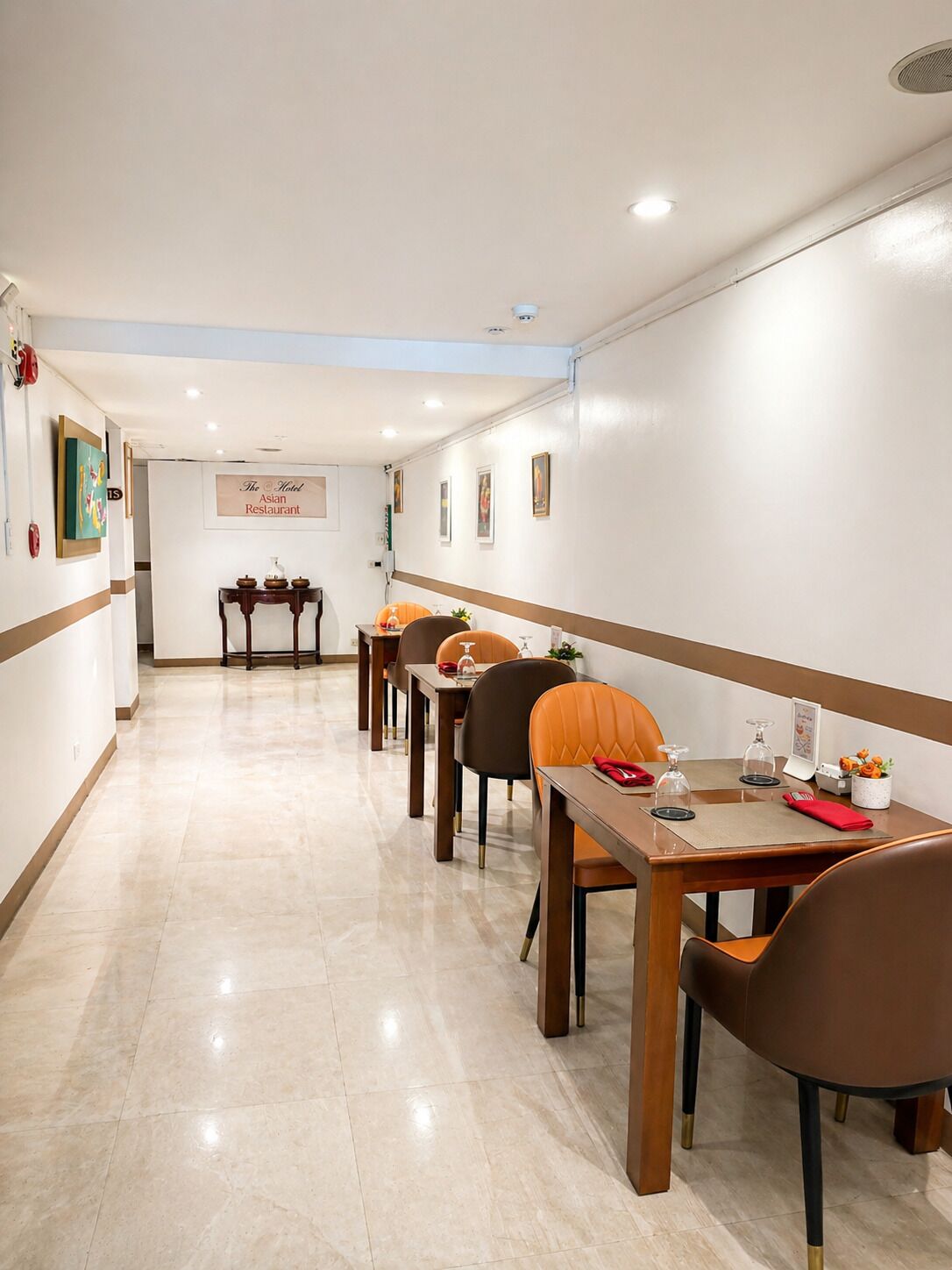 A hotel dining area with a long table, chairs, and a sign indicating it's an Asian restaurant.